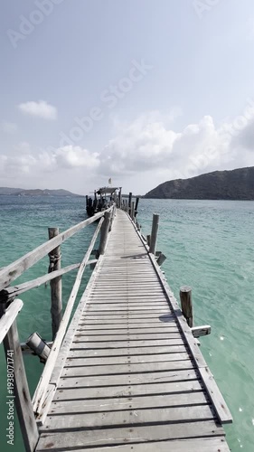 Scenic wooden pier walkway over turquoise waters coastal paradise landscape photography sunny day aerial perspective