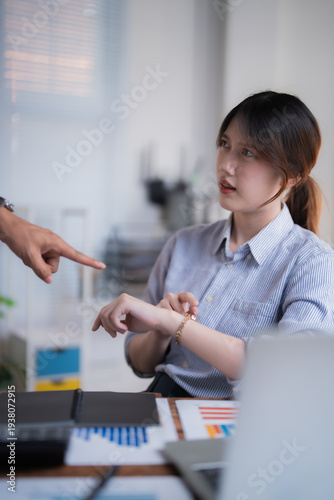 Фотография Stressed employee being scolded by boss pointing at watch, tense office confront