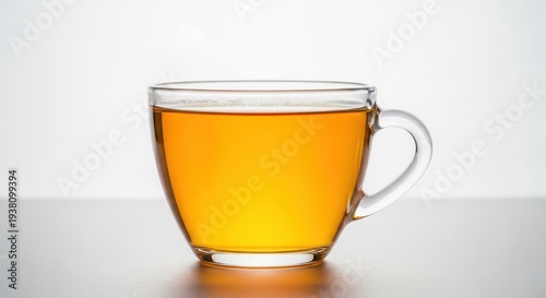 Bright golden infusion in a clear glass cup, highlighting the rich amber color of the warm, flavorful, healthy beverage, comforting, rich, nourishment