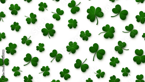 Shamrocks are scattered across a bright white background creating a festive repeating pattern ideal for St. Patrick's Day textile design or greeting cards.