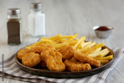 Fried Chicken Nuggets and French Fries with Barbecue Sauce, low angle view. Close-up.