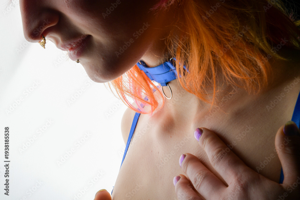 Fototapeta premium Sinnliches Porträt einer Frau mit Halsring und farbigem Haar. Ästhetische Low-Key Szene über BDSM-Symbolik, Fetisch, Selbstbestimmung, Intimität und moderne Fetischkultur.