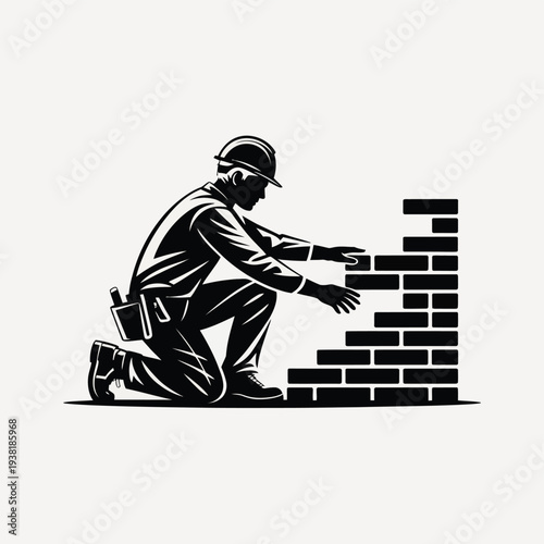 Man building brick wall with construction hat and tool belt on kneeling down to place bricks