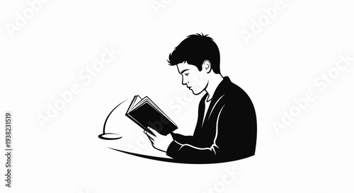 A young man in a suit reading a book at a desk