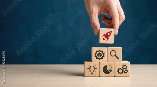 Businessman hand placing a wooden block with a rocket icon on a stack of business strategy cubes.