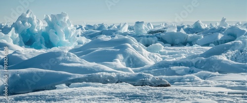 Blue and white ice blocks spread across snow hummocks on a frozen lake in a bright cold winter scene
