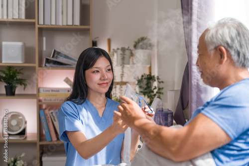 Bilde på lerret Professional young female caregiver supporting elderly male patient using oxygen inhalation machine in bedroom