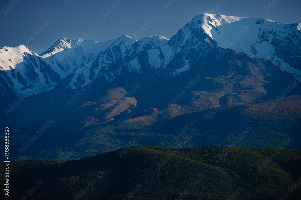 Fototapeta premium Majestic snow-capped Altay mountain range under clear blue sky at dusk