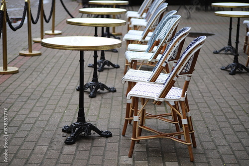 Empty chairs and round tables outside a café during rain, Riga, Latvia