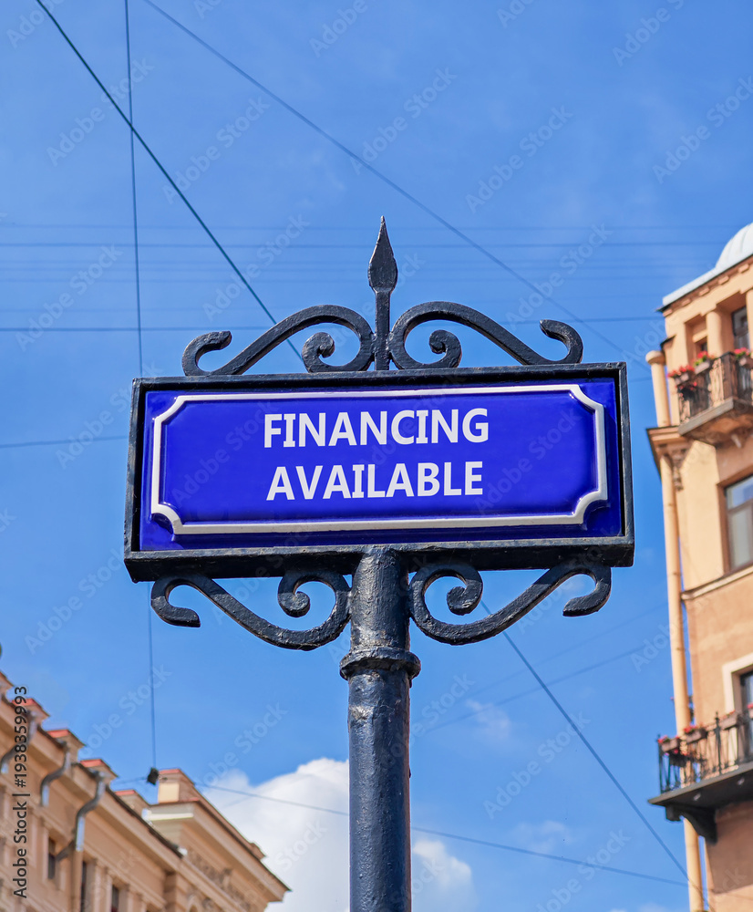 Fototapeta premium Financing available symbol. Concept words Financing available on beautiful big blue road sign. Beautiful blue sky and buildings background. Business financing available concept. Copy space.