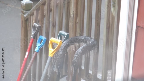 snow shovel handles coated in freezing rain in February