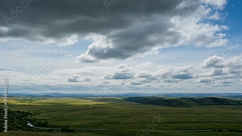 Scenic view of a lush green landscape under a dramatic cloudy sky