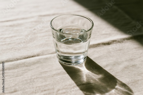 Glass of water on fabric surface