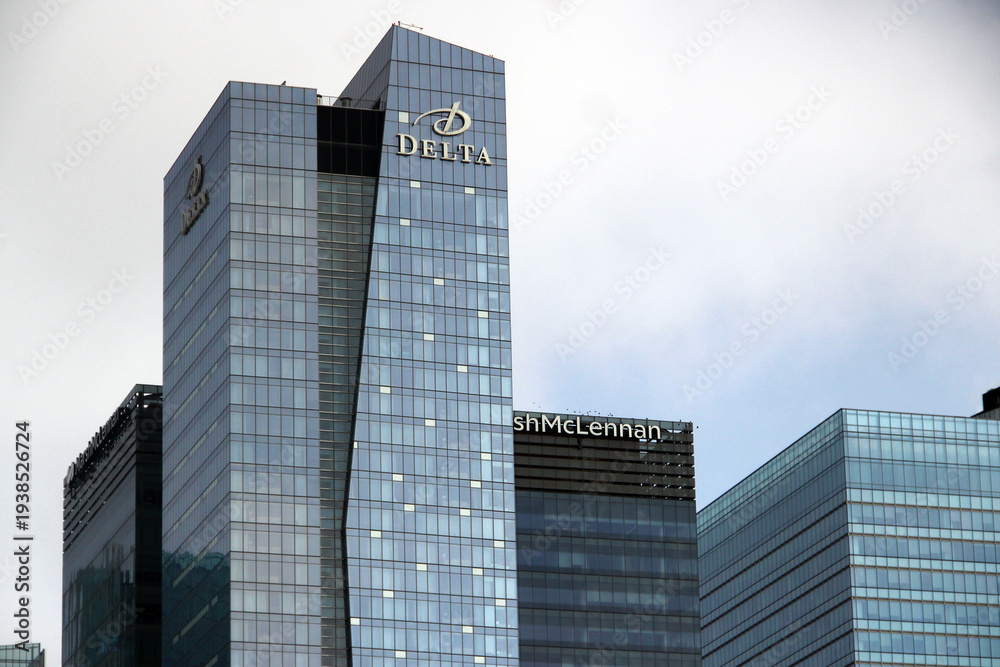 Obraz premium Toronto, Canada - February 15, 2026: Modern glass office towers in downtown Toronto featuring the Delta building and Marsh McLennan headquarters under a cloudy urban skyline