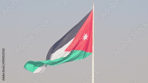 Aerial view The Raghadan Flagpole dominates the Amman skyline, Jordan. This monumental national flag towers over traditional limestone architecture and the dense urban hillside of the capital.