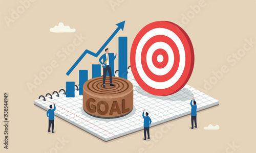 Business businessman on wooden stamp with alphabet building the word GOAL on graph paper notebook with other people admiring