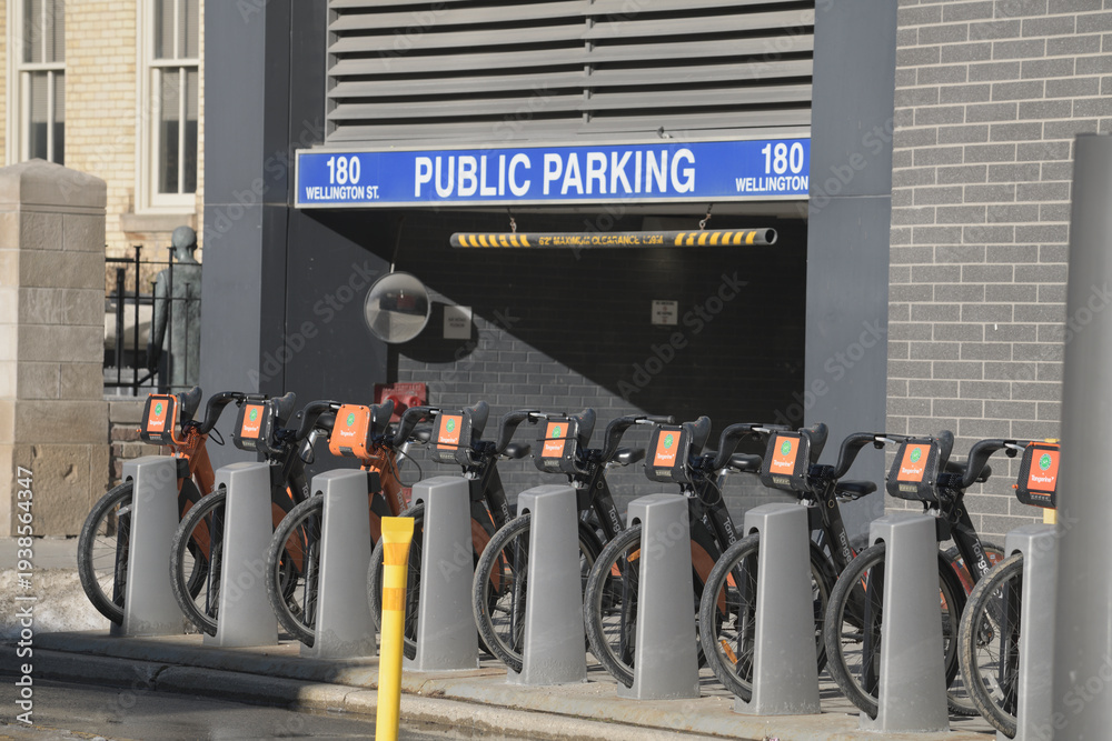 Fototapeta premium Bike Share Toronto docking station near entrance to Public Parking at 180 Wellington St W