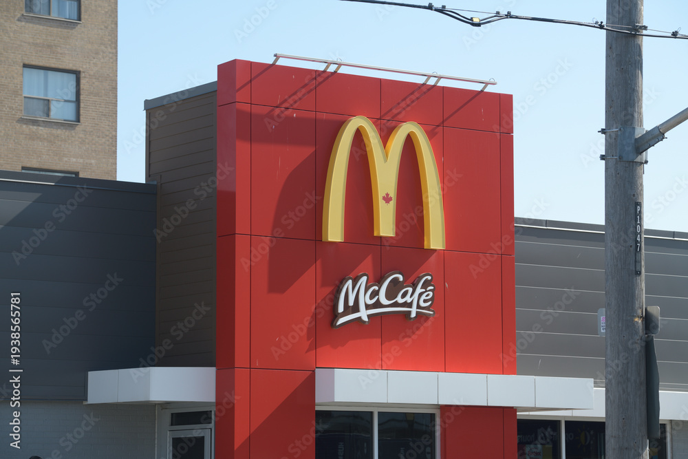 Obraz premium exterior building facade and sign of McDonald's + McCafé fast food chain located here at 1045 Pape Av, Toronto