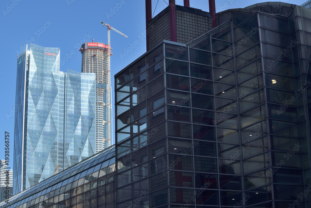 Fototapeta premium (in the shadows) exterior of SkyWalk a bridge and a defocused view of CIBC Square and SkyTower at Pinnacle One Yonge, Toronto
