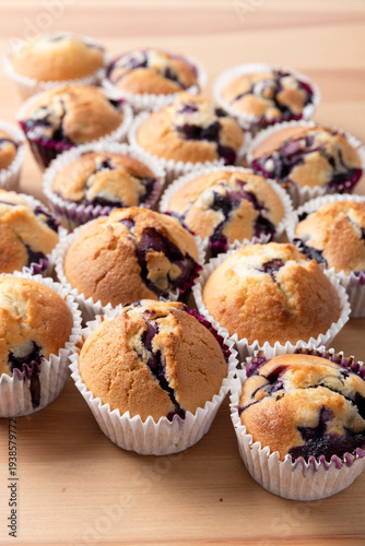 Batch of Homemade Blueberry Muffins on Wood Background