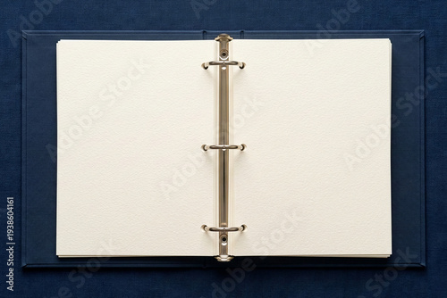 Open dark blue ring binder with blank pages on matching background