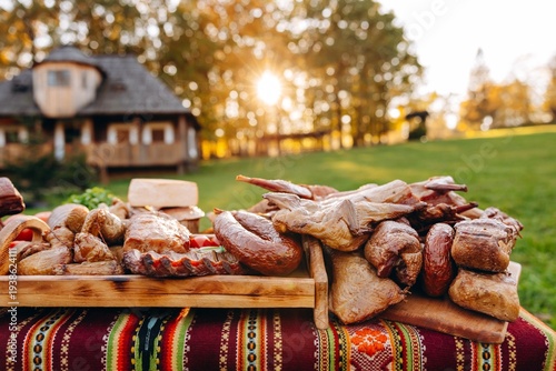 Smoked meats and sausages on wooden boards at an outdoor country barbecue sunset picnic
