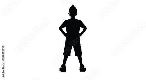 Silhouette of a young boy standing confidently with hands on hips and feet apart