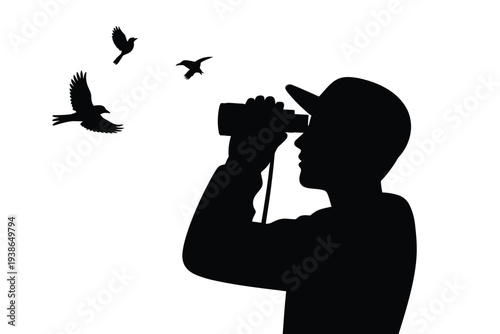Silhouetted birdwatcher observes flying birds with binoculars