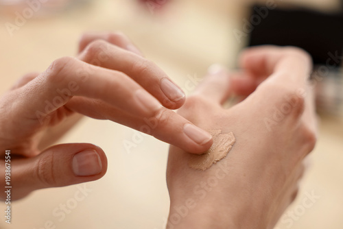 Canvas Print Woman testing foundation on hand indoors, closeup