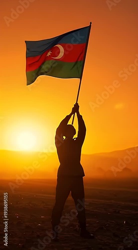 Silhouette of person holding Azerbaijan flag against sunset backdrop