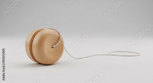 A simple, classic wooden yo-yo with a white string, resting on a clean white background, ready for play.