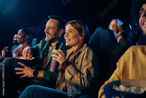 Happy couple watching movie in theater.