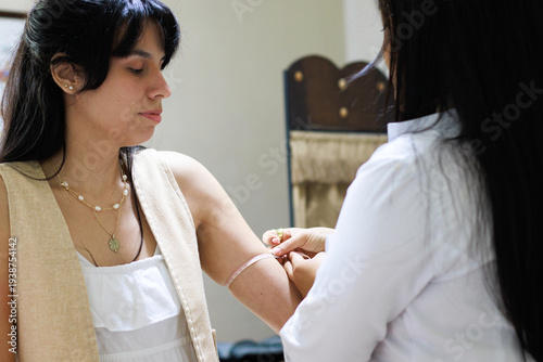 Nutritionist calculating arm circumference with a measuring tape on a young woman for health check and diet treatment