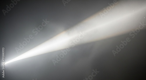 A bright beam of light shining through a dark and foggy atmosphere