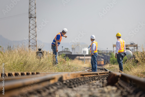 Asian railway engineers surveying railroad tracks and infrastructure project at site, Group of transportation experts inspecting railroad switching point for safety and logistics