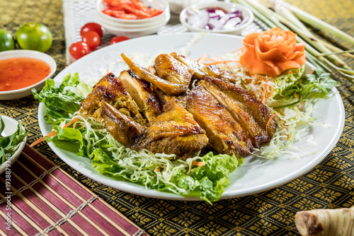 Slices of roasted duck breast arranged on fresh salad greens with dipping sauce. The elegant presentation is suitable for Chinese cuisine menus festive dining and roasted meat promotion.