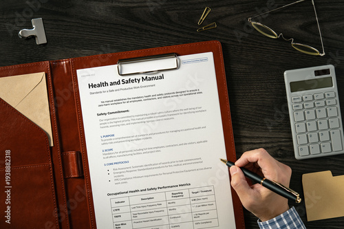 Health and Safety Manual: Realistic mock-up mock placed on  with calculator, pen. Contributor-created fictional business document for illustrative purposes.