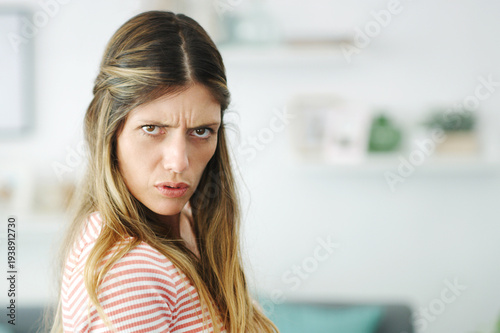 Free Download Portrait, angry and woman in home, upset and conflict for argument, facial expression and emotion. Apartment, reaction and person in living room, disagree and negative with bad feedback and furious - GFXLoad