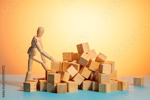 Wooden mannequin looking over scattered wooden blocks, sorting chaos concept