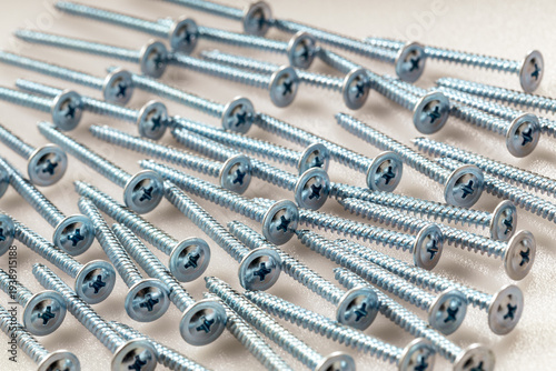 Industrial hardware: zinc finish screws on clean white plastic