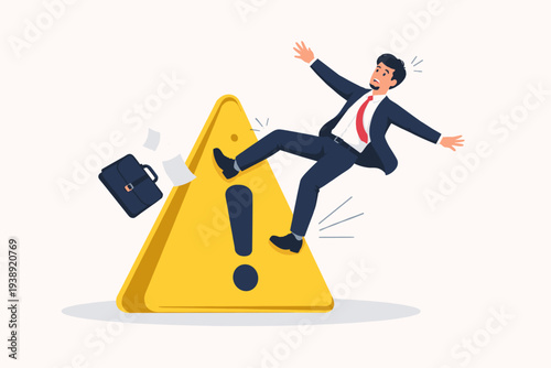 Businessman falling over a huge yellow warning sign with exclamation mark, concept of business risk, failure, mistake, crisis management, and accident prevention in professional workplace.