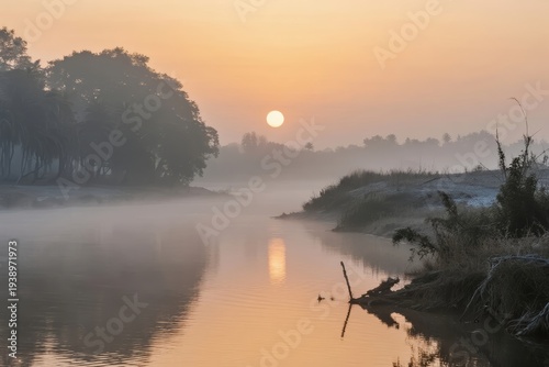 Sunrise over a misty river with calm water reflecting the sun and surrounding trees