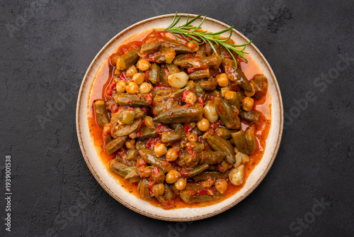 Fotografie Freshly cooked okra dish on black stone table background