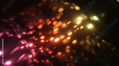 Abstract Light Reflections on Water Surface Creating Dynamic and Colorful Bokeh Patterns.