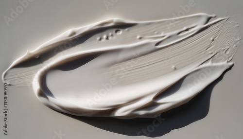 Creamy white cosmetic swirl on smooth background shows rich texture and spreadability