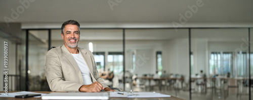Photos Happy middle aged business man ceo sitting at office desk