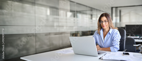 Cuadro en lienzo Busy middle aged business woman using laptop working in corporate office