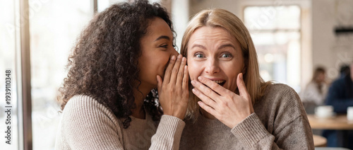 Intimate whisper shares an astonishing secret, sparking wide-eyed wonder and genuine surprise in a friend at a sunlit cafe