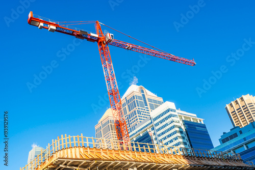 A red  construction crane against blue sky, Calgary, Canada