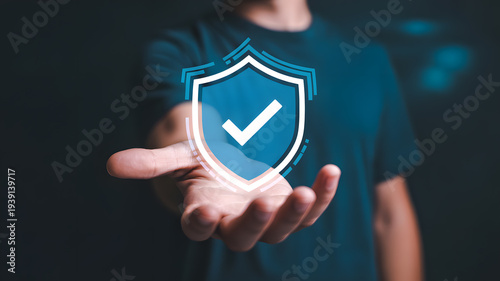 A person holding a digital shield with a checkmark in their hand